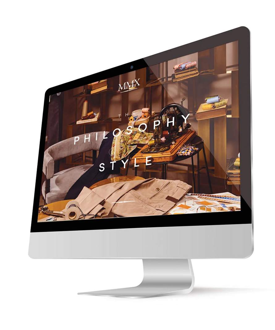 Computer monitor displaying a luxurious interior design website with 'MMX' branding.